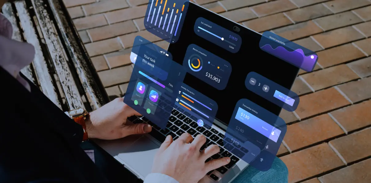 Man working on a laptop displaying a SAP ERP dashboard interface.